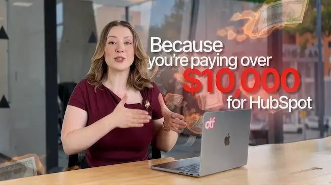 Gabrielle Paris, VP of sales at On The Fuze, presenting HubSpot Support at a desk with a laptop, surrounded by flying dollar bills. Large text reads, “you’re paying over $10,000 for HubSpot.”