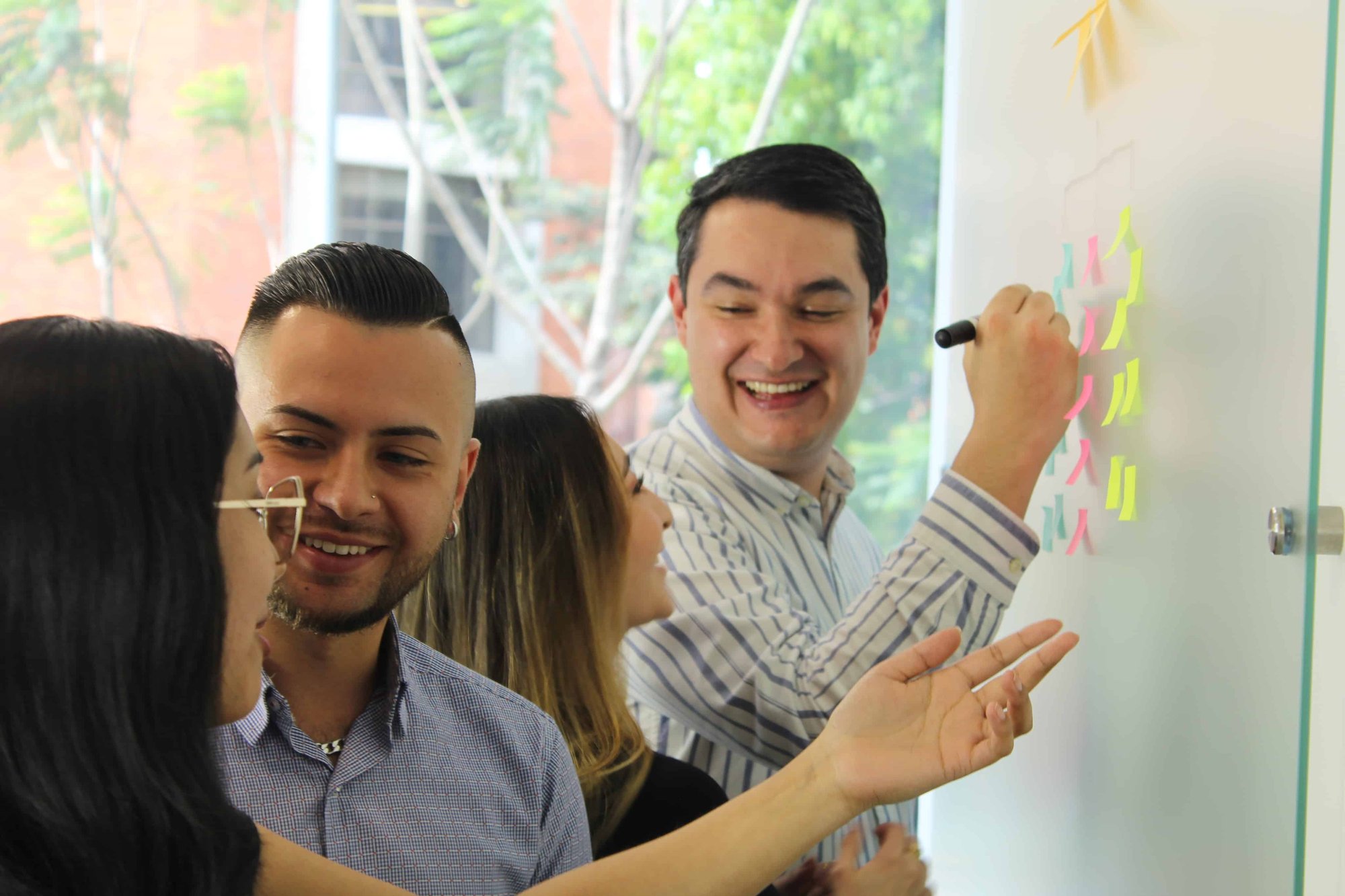 On The Fuze team members celebrating success with raised hands in bright office setting